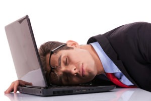 Tired business man sleeping on his laptop computer